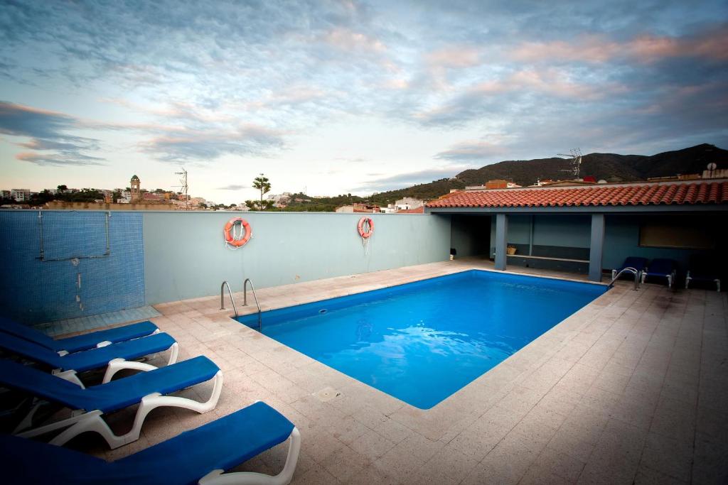a swimming pool on the roof of a house at Hotel Beri in Llança