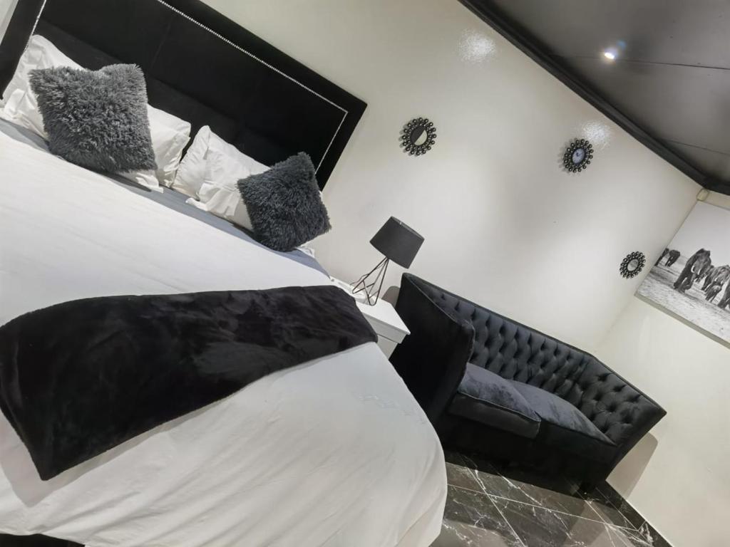 a bedroom with a large bed with a black headboard at Semeni Asante Guesthouse in Johannesburg