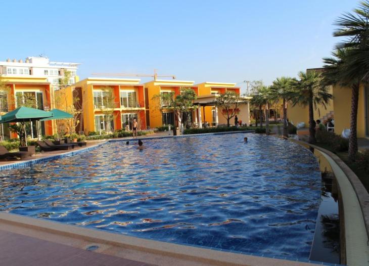 a large swimming pool in front of some buildings at bangkok grand resort in Bang Bo