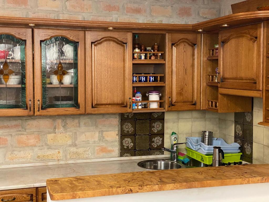 kuchnia z drewnianymi szafkami i zlewem w obiekcie Balaton7 Apartmanház - Badacsonytomaj Centrum w mieście Badacsonytomaj