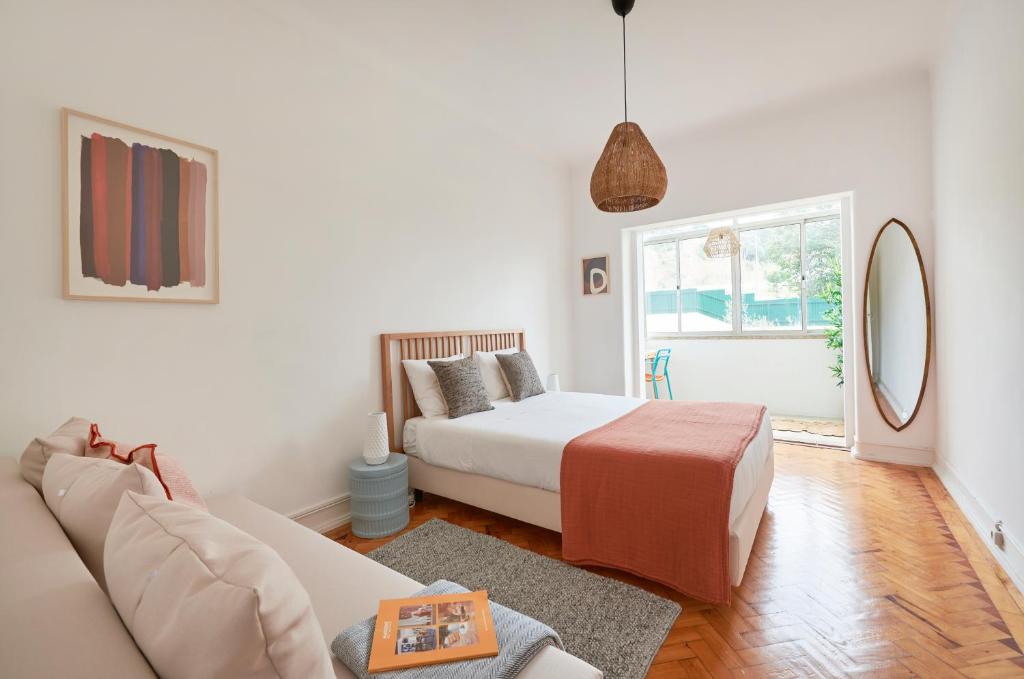 uma sala de estar com uma cama e um sofá em Light-Filled & Renovated Apartment, By TimeCooler em Lisboa