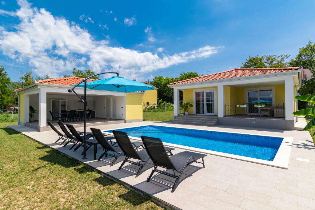 - une piscine avec des chaises et un parasol à côté d'une maison dans l'établissement Villa Mario with private heated saltwater pool, à Kršan