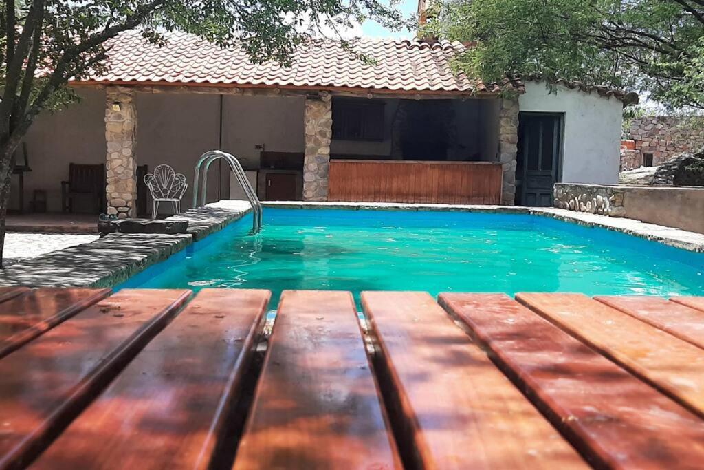basen z drewnianą ławką przed domem w obiekcie Residencia en Tomatitas w mieście Tarija