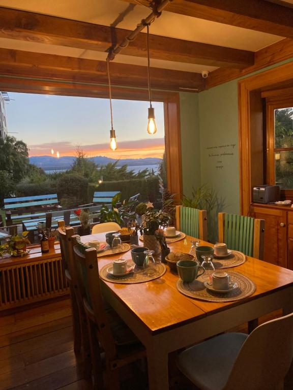 a dining room table with chairs and a large window at Selva India Suites in San Carlos de Bariloche