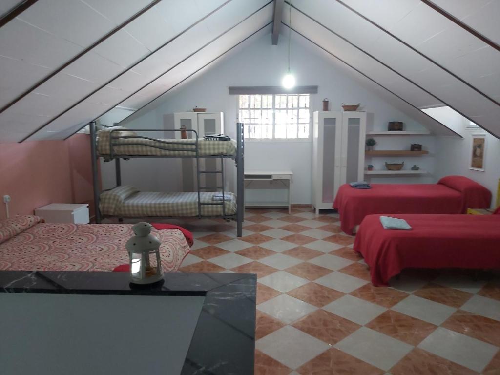 a attic room with two bunk beds and a checkered floor at Casa Selene in El Puerto de Santa María