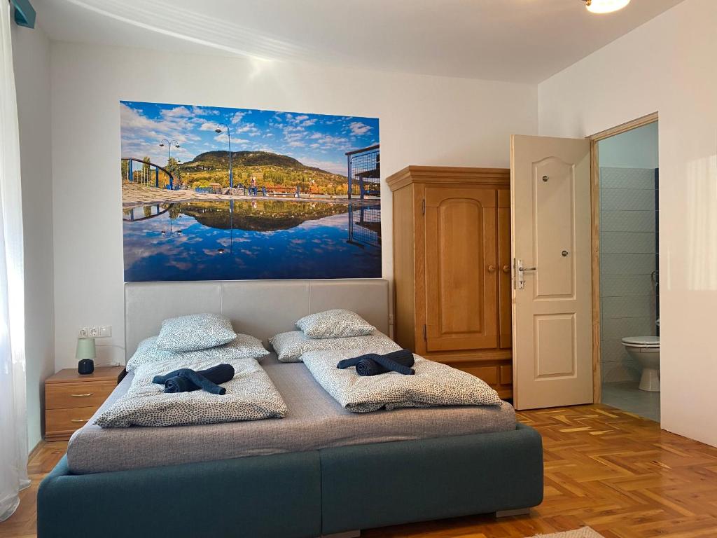 sypialnia z łóżkiem i obrazem na ścianie w obiekcie Balaton7 Apartmanház - Badacsonytomaj Centrum w mieście Badacsonytomaj