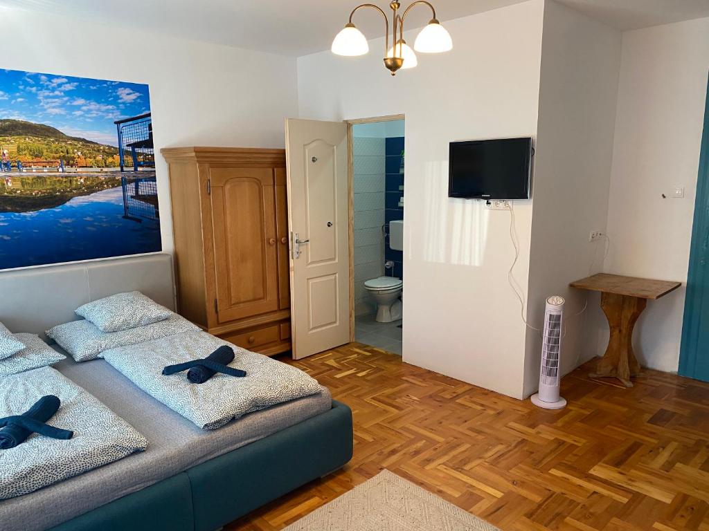 Pokój z łóżkiem z ręcznikami i telewizorem w obiekcie Balaton7 Apartmanház - Badacsonytomaj Centrum w mieście Badacsonytomaj
