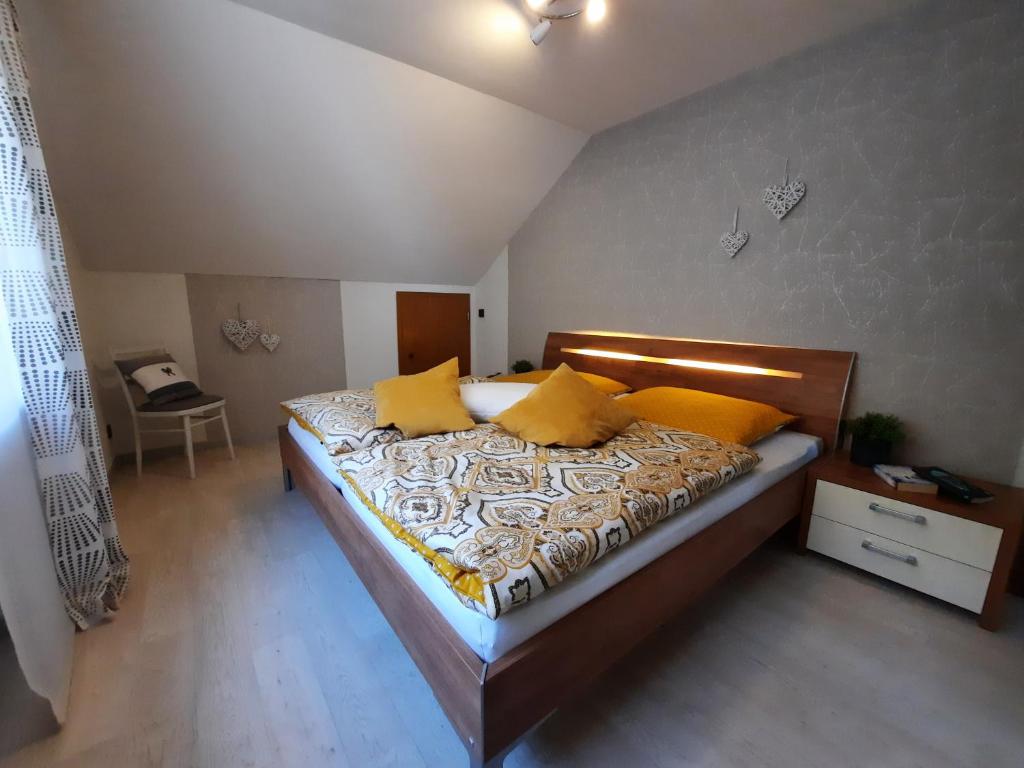 a bedroom with a large bed with yellow pillows at Ferienwohnung Im Bachtal in Pommern
