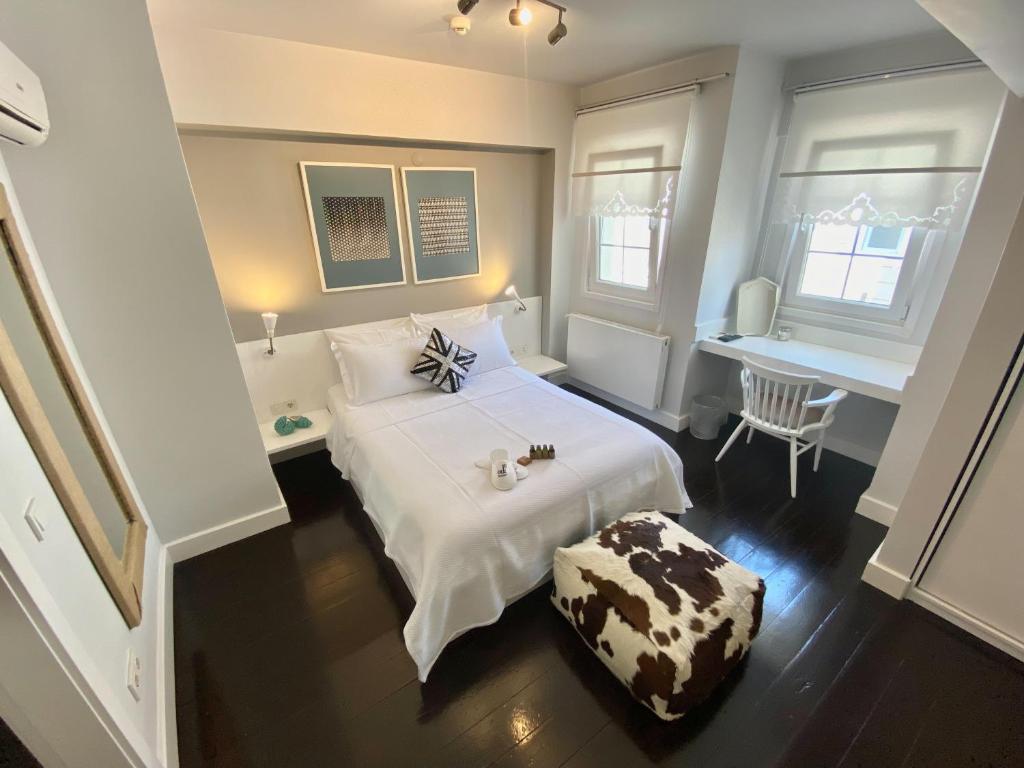 a bedroom with a white bed and a desk at 19 Oda Bozcaada in Çanakkale