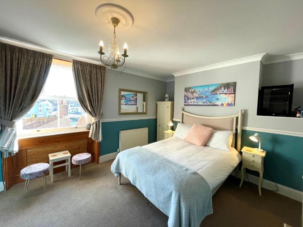 Schlafzimmer mit einem Bett und einem Fenster in der Unterkunft Bayliss Hall Guesthouse in Weymouth