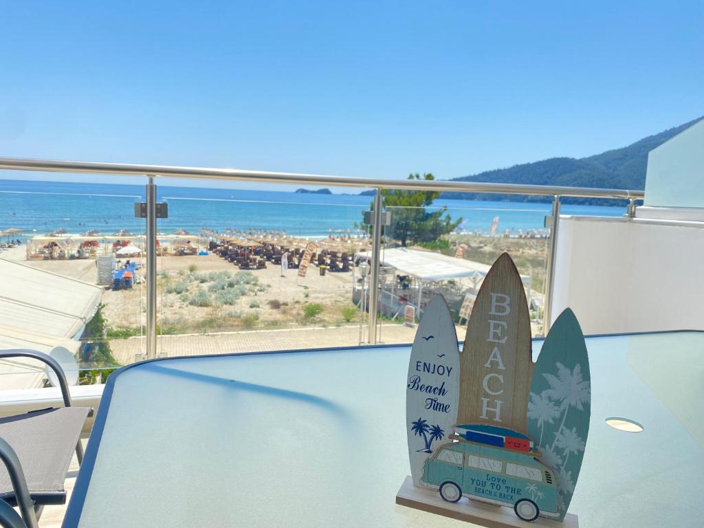 a table with two surfboards on it with a view of a beach at Ifigenia Sea View Apartments in Chrysi Ammoudia