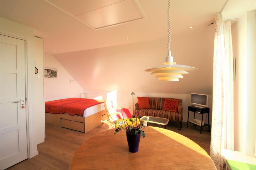 1 dormitorio con 1 cama y 1 mesa con flores en Ollediek, en Houwerzijl