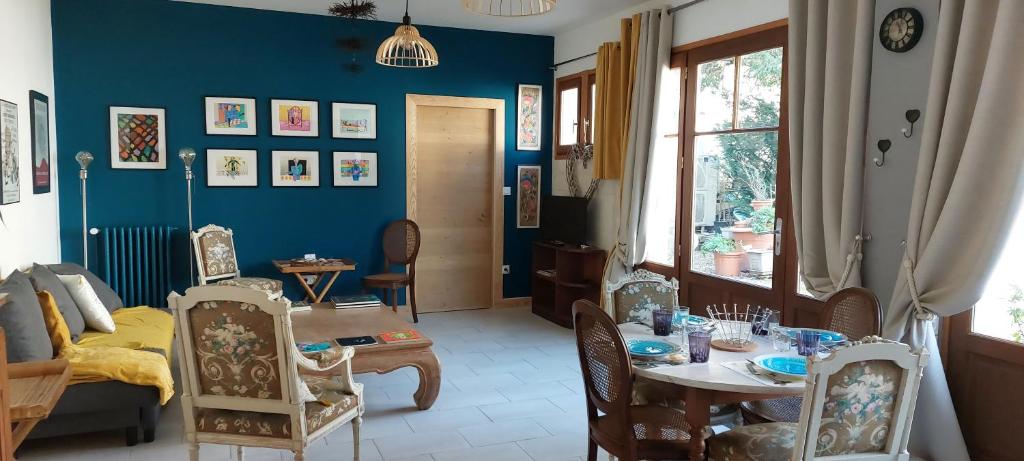 a living room with a table and a blue wall at Rêve de Charme in Montrichard