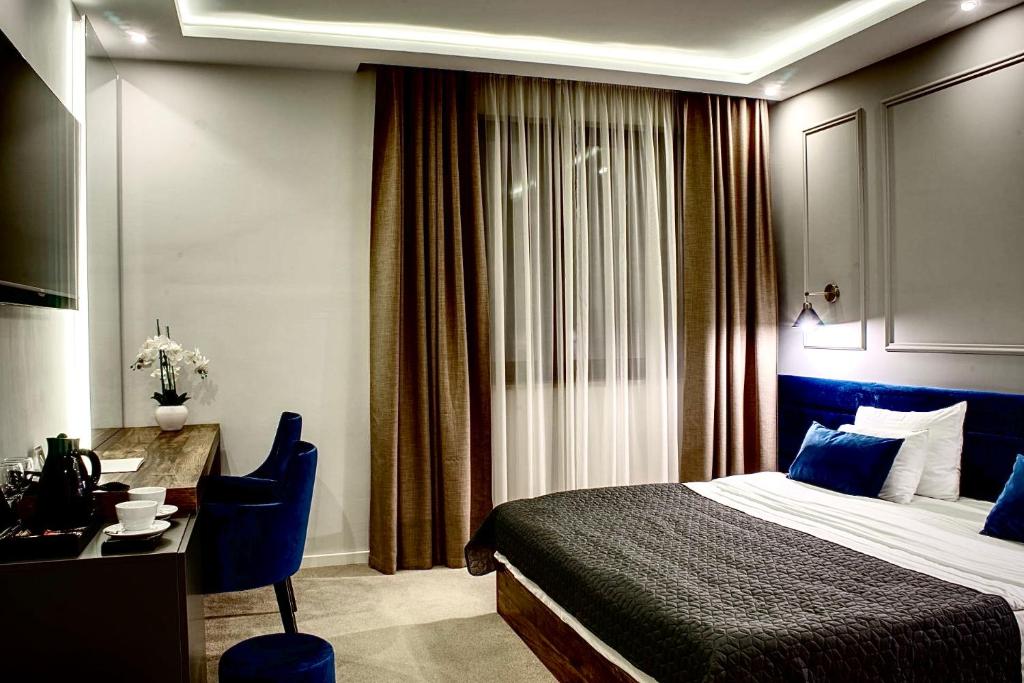 um quarto de hotel com uma cama e uma secretária e uma mesa e cadeira em IG Hotel em Gornji Milanovac