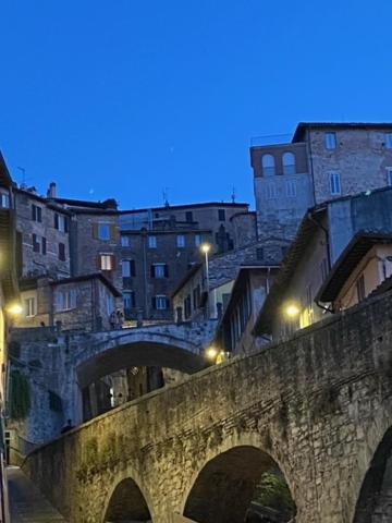 un viejo puente de piedra con edificios en el fondo en Artist apartment centro storico, en Perugia