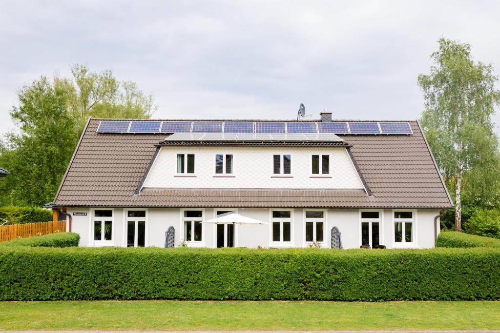 a white house with solar panels on the roof at Drum &Dran in Kühlungsborn