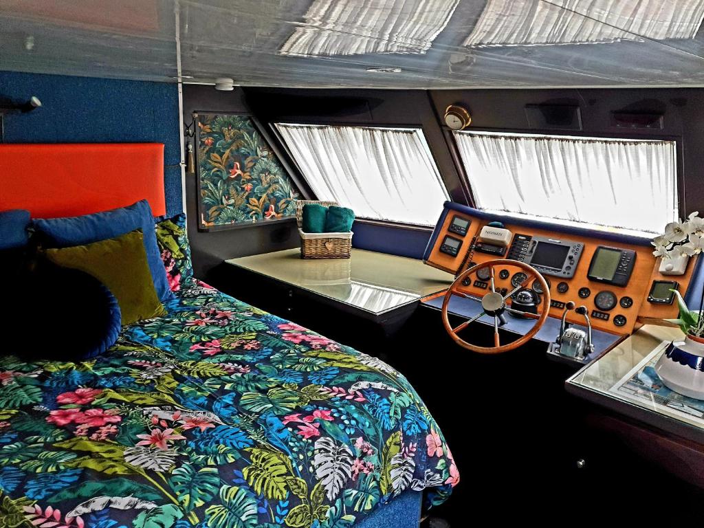 um quarto com uma cama e um volante em JASMINE CORAL JAY Boutique Boatel Ocean Village em Gibraltar