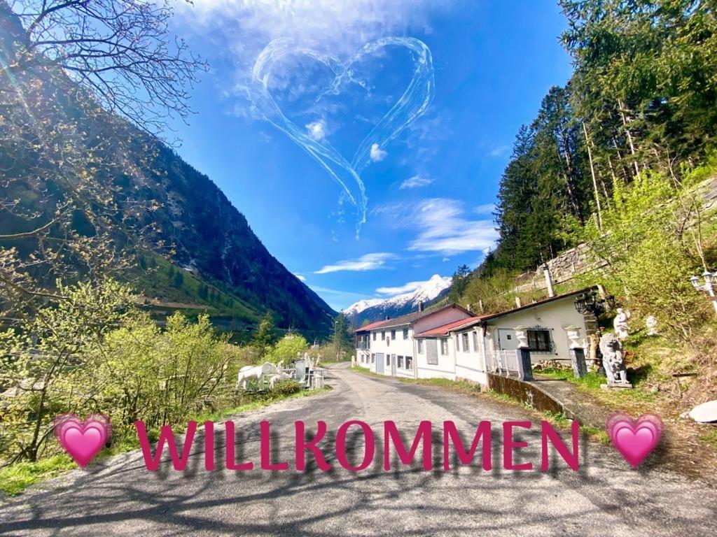 a road in the mountains with the words will kommen at Boxenstopp Gurtnellen in Gurtnellen