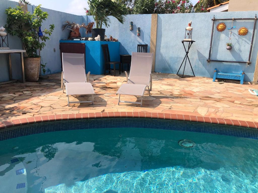 a pair of chairs sitting next to a swimming pool at Mo Place in Paradera