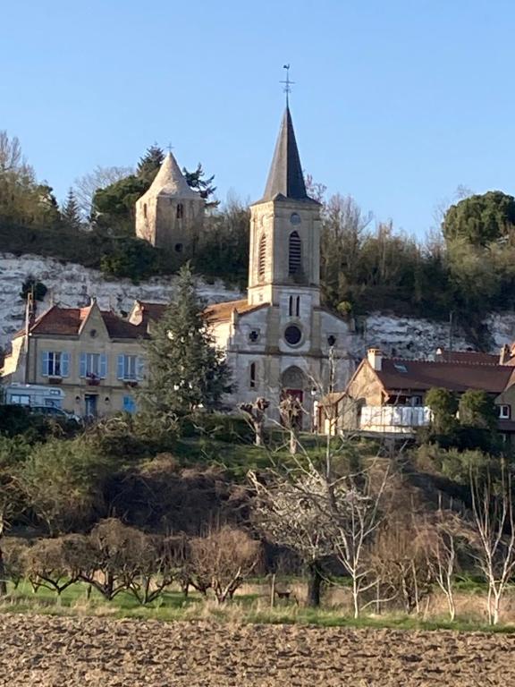 Maison calme et fonctionnelle في Mousseaux-sur-Seine: كنيسة قديمة على قمة تلة