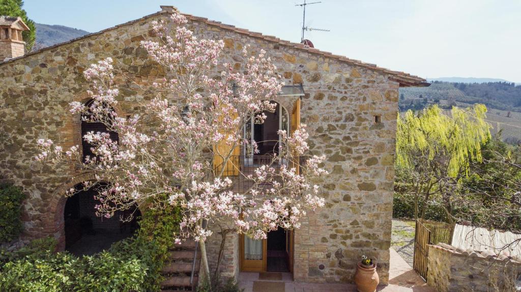 ein Steinhaus mit einem Baum davor in der Unterkunft La Magnolia in Greve in Chianti