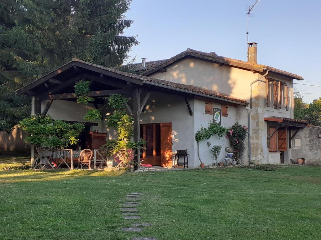 une petite maison blanche avec une cour d'herbe dans l'établissement La Grange, à Le Plan