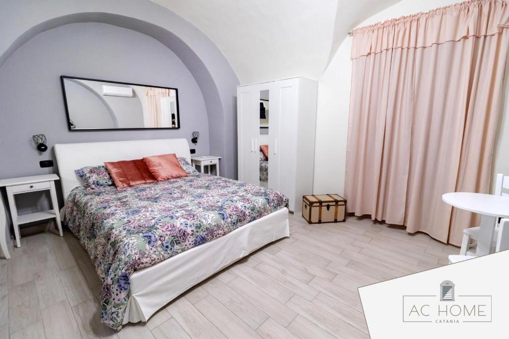 a bedroom with a large bed and a mirror at AC HOME in Catania