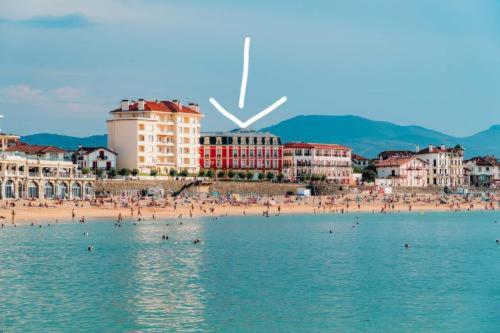 a group of people swimming in the water at a beach at Appartement pied de plage in Saint-Jean-de-Luz
