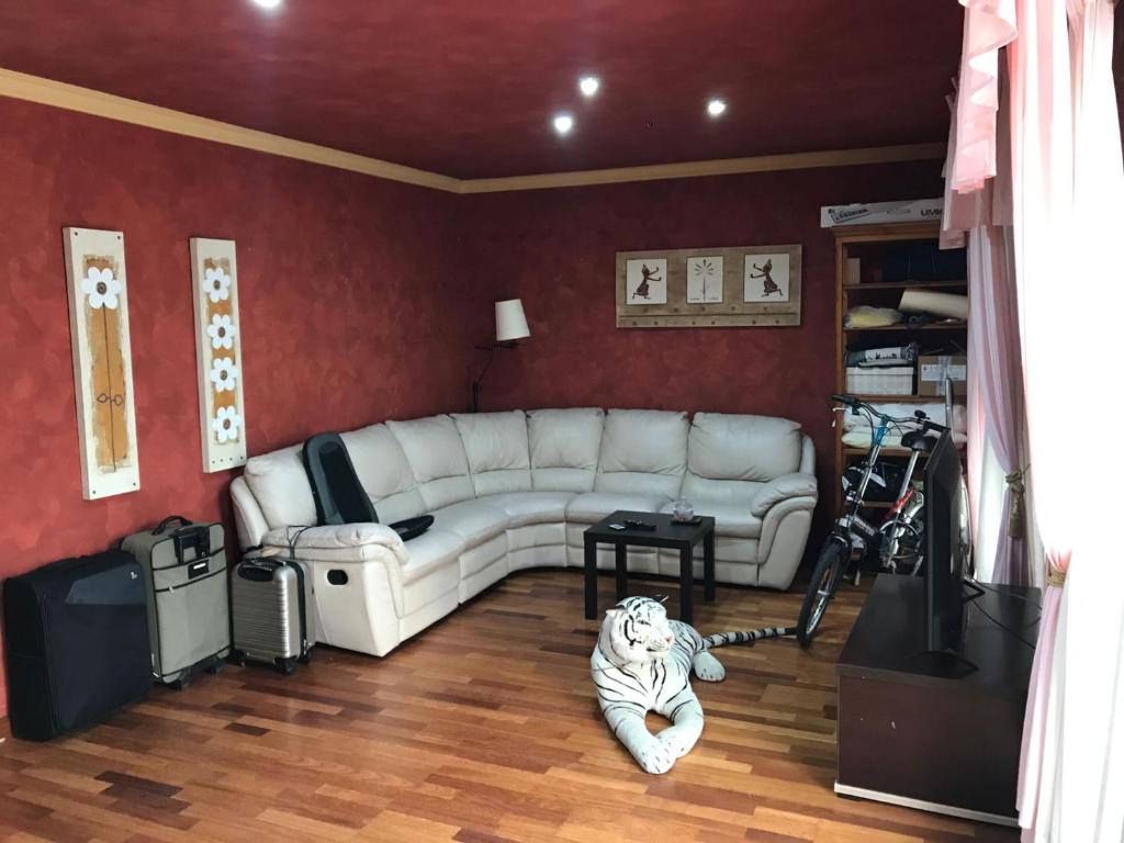 una sala de estar con un sofá blanco y un tigre tirado en el suelo en Los Girasoles, en Fuengirola