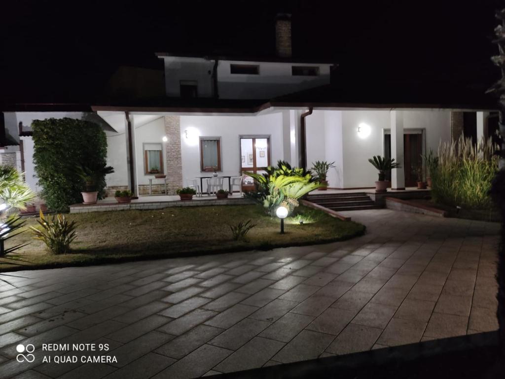 una casa iluminada por la noche con un patio en Villa Aristogatti, en San Pietro Vernotico