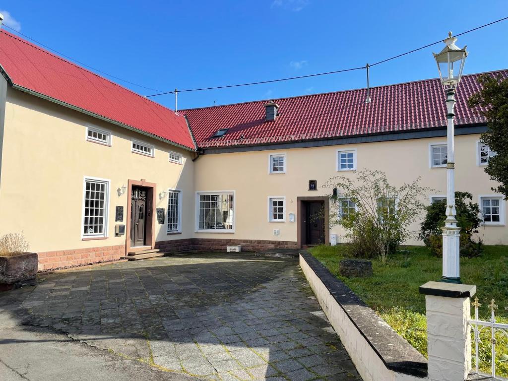 un bâtiment avec un toit rouge et une cour dans l'établissement Villa Maaremonte, à Üdersdorf