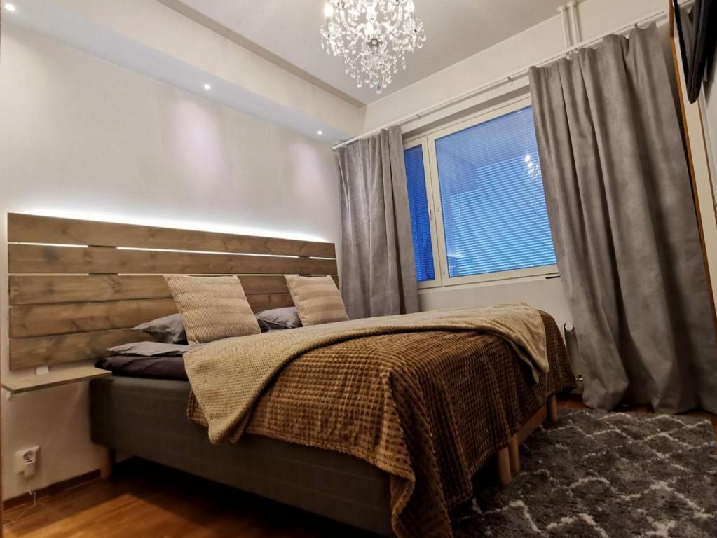 una camera da letto con un letto con un lampadario a braccio e una finestra di Rovaniemi Cityhome Laura a Rovaniemi