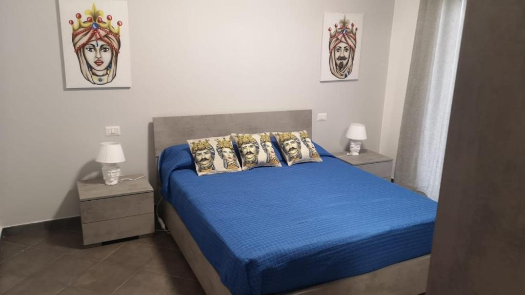 1 dormitorio con 1 cama con sábanas y almohadas azules en CASA del MORO, en Giardini Naxos