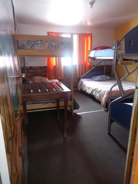 a room with two bunk beds and a table at Monkeywasi Climbing Hostel in Huaraz