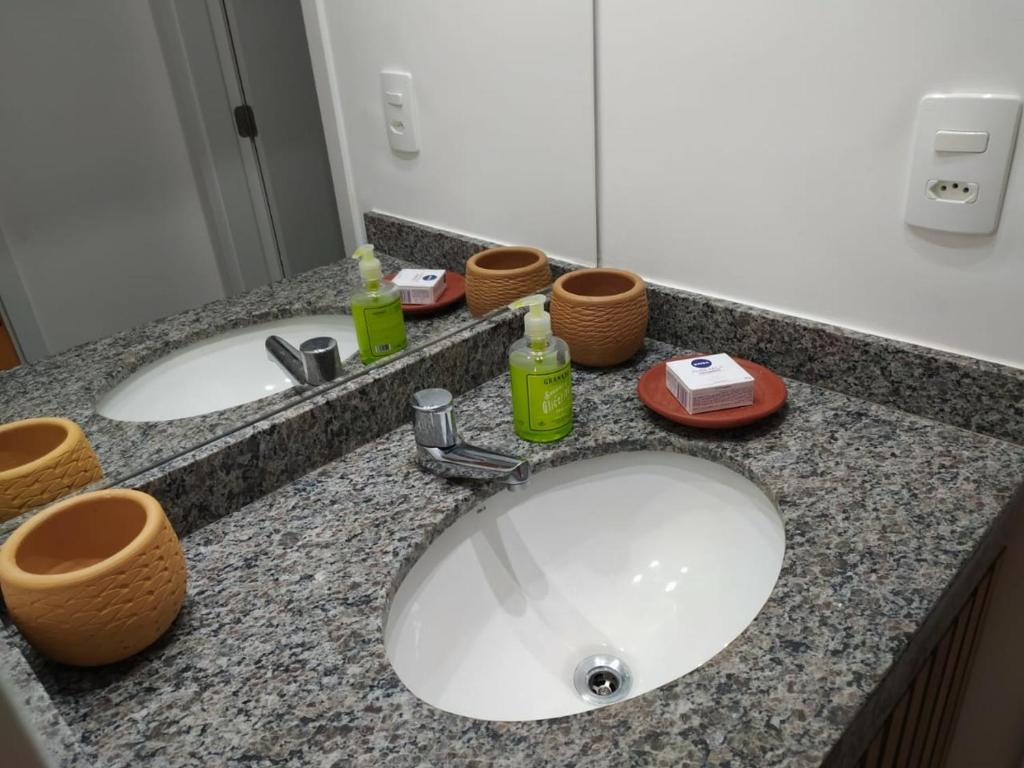 a bathroom counter with two sinks and a mirror at Flat em Guarajuba, Paraíso dos Coqueiros in Guarajuba
