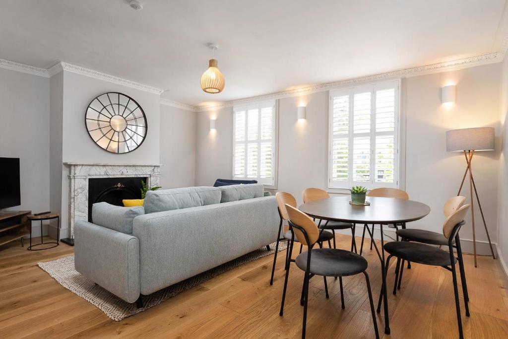 a living room with a couch and a table at Period Henley 2 bed apt with parking for 1 car in Henley on Thames
