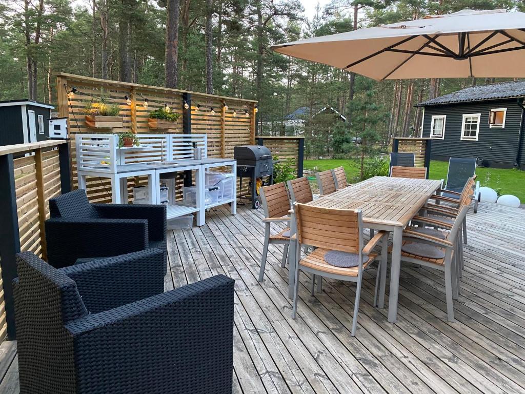 patio ze stołem, krzesłami i parasolem w obiekcie Havsnära paradis w mieście Yngsjö
