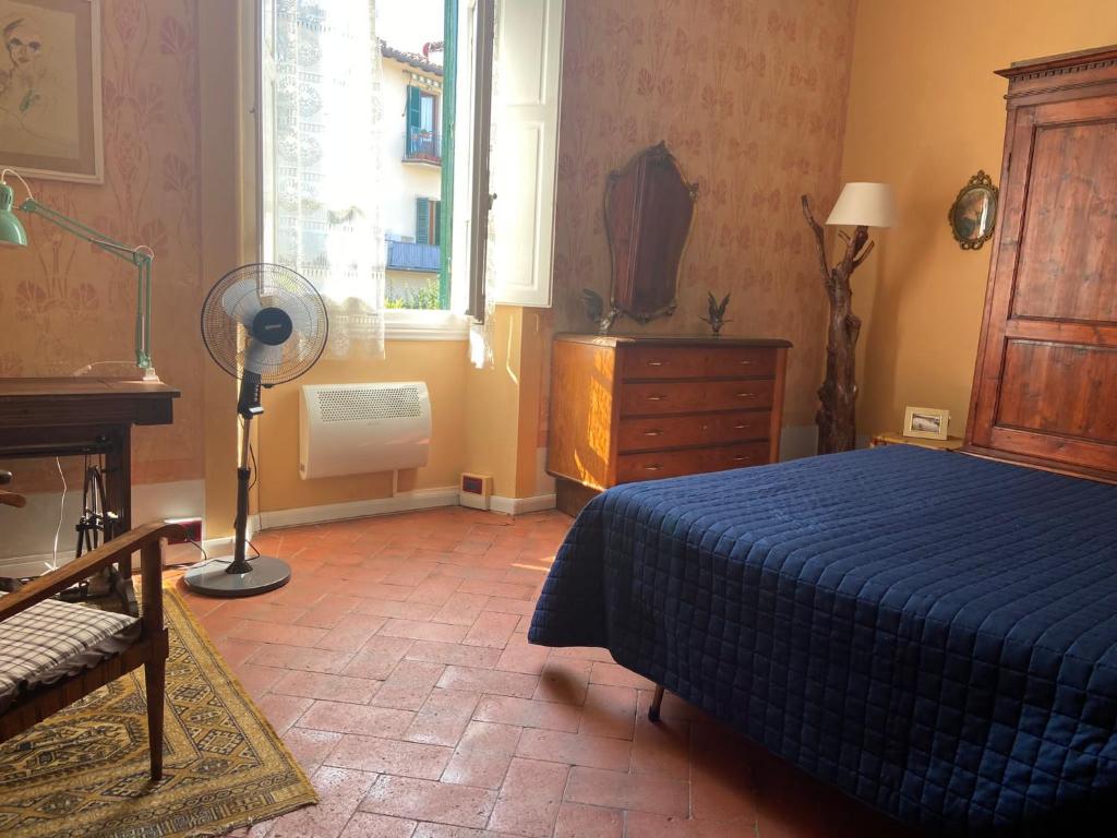 a bedroom with a blue bed and a window at LA BARRIERA UNO in Florence