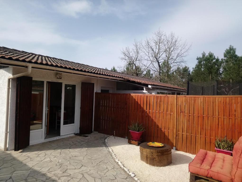 a fence in front of a house with a patio at Bassin d'Arcachon - studio Ares - in Arès