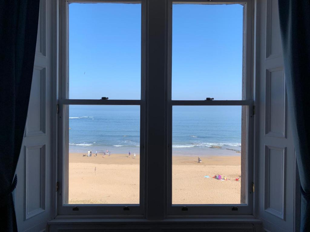 an open window with a view of a beach at Bass Rock Beachside Flat in North Berwick