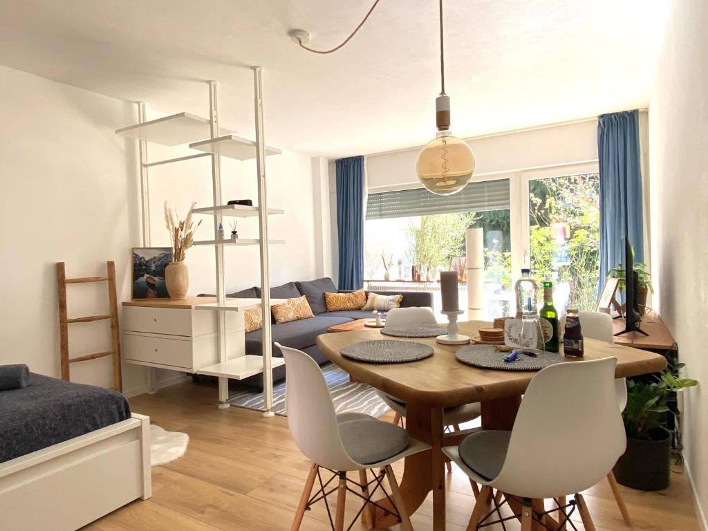 a dining room and living room with a table and chairs at Ferienwohnung Schwarzwaldstraße in Pforzheim