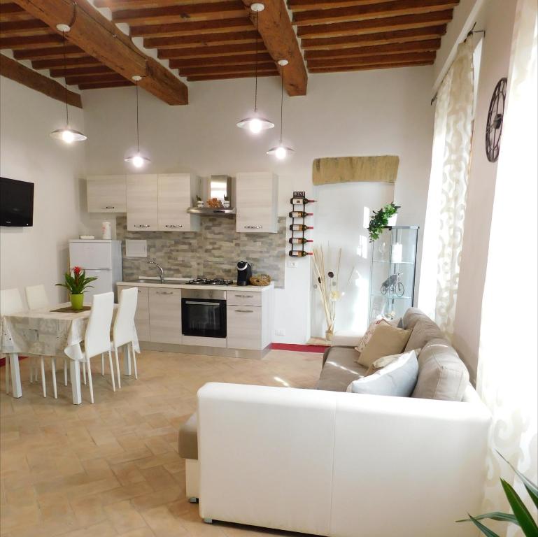 a living room with a couch and a kitchen at Otello Guest House in Montalcino