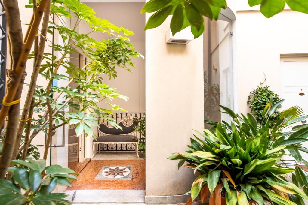 a courtyard of a house with plants and a bench at Moncada Suites & Apartments in Palermo