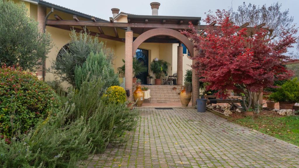 uma casa com um passadiço de tijolos em frente em B&B LA VILLA em Forlì