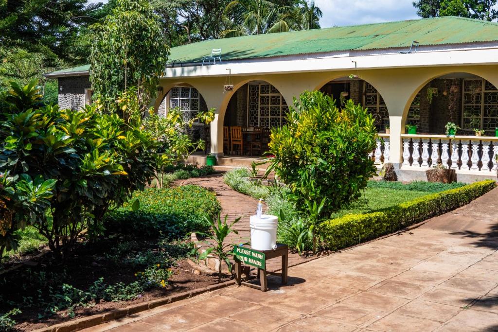 une maison avec un jardin et une bougie sur un banc dans l'établissement Kiwavi Home, à Moshi