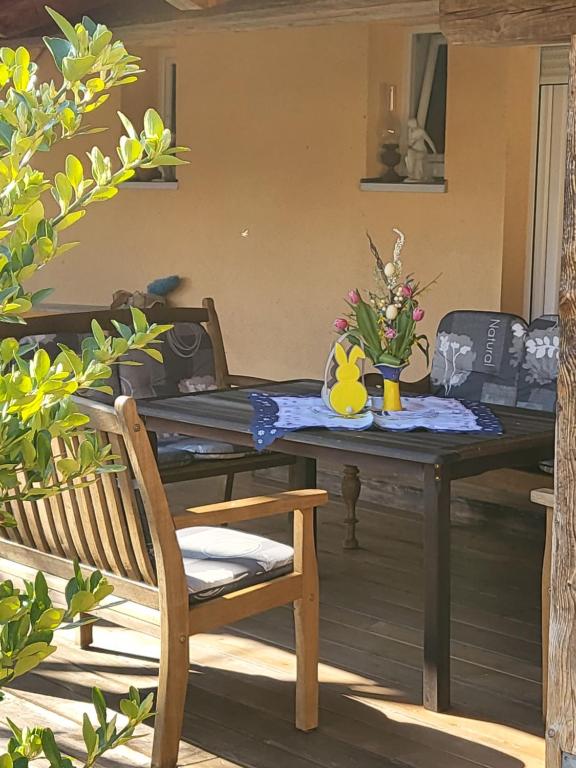 une table avec un vase de fleurs sur elle dans l'établissement EHM Family Resort, à Mesteri