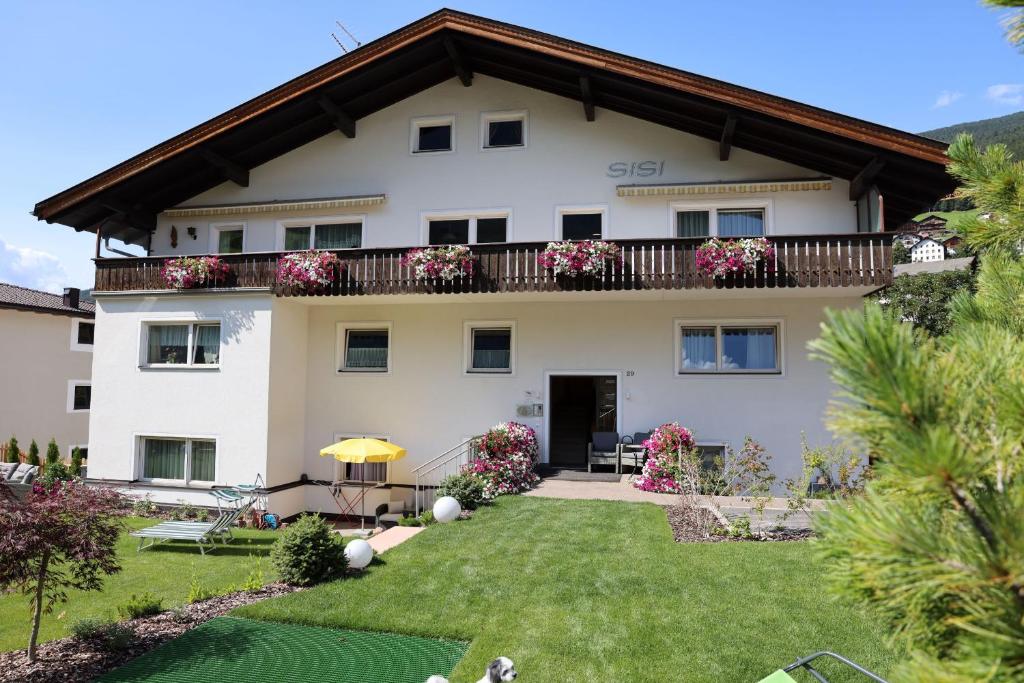 una grande casa bianca con balcone di Residence Sisi a Ortisei