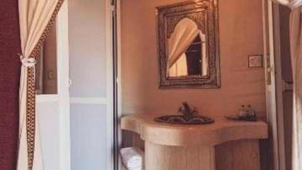 a bathroom with a sink and a mirror at Erg Chebbi Luxury Camp in Merzouga
