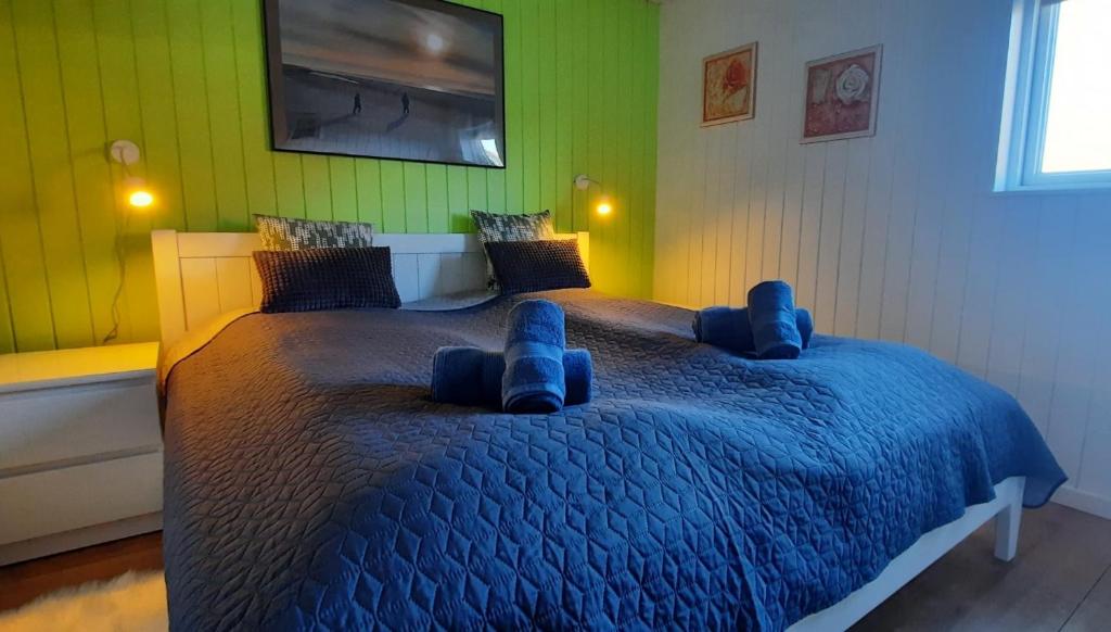 a bedroom with a large bed with blue cushions at Gadegaard Apartment in Ringkøbing