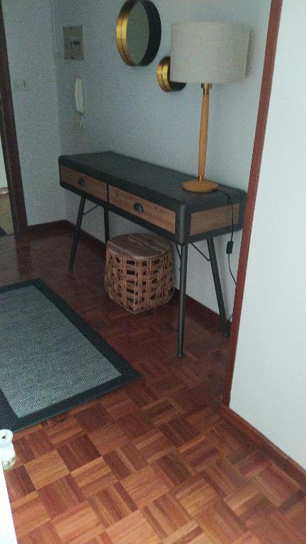 einen Tisch in einem Zimmer mit einer Lampe auf einem Schreibtisch in der Unterkunft Habitación Alex , es un quinto sin ascensor in Pontevedra